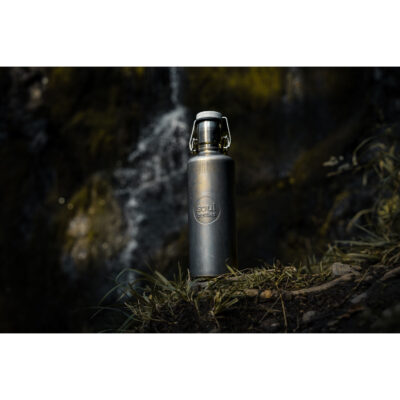 Soulbottle Steel Insulated Industrial (0,6 l) Edelstahl Thermosflasche vor einem Bachlauf stehend